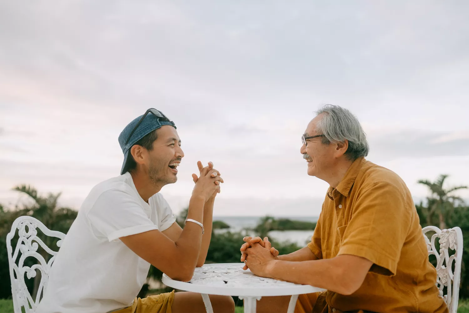 Adult Man Talking to Father on White Garden Table