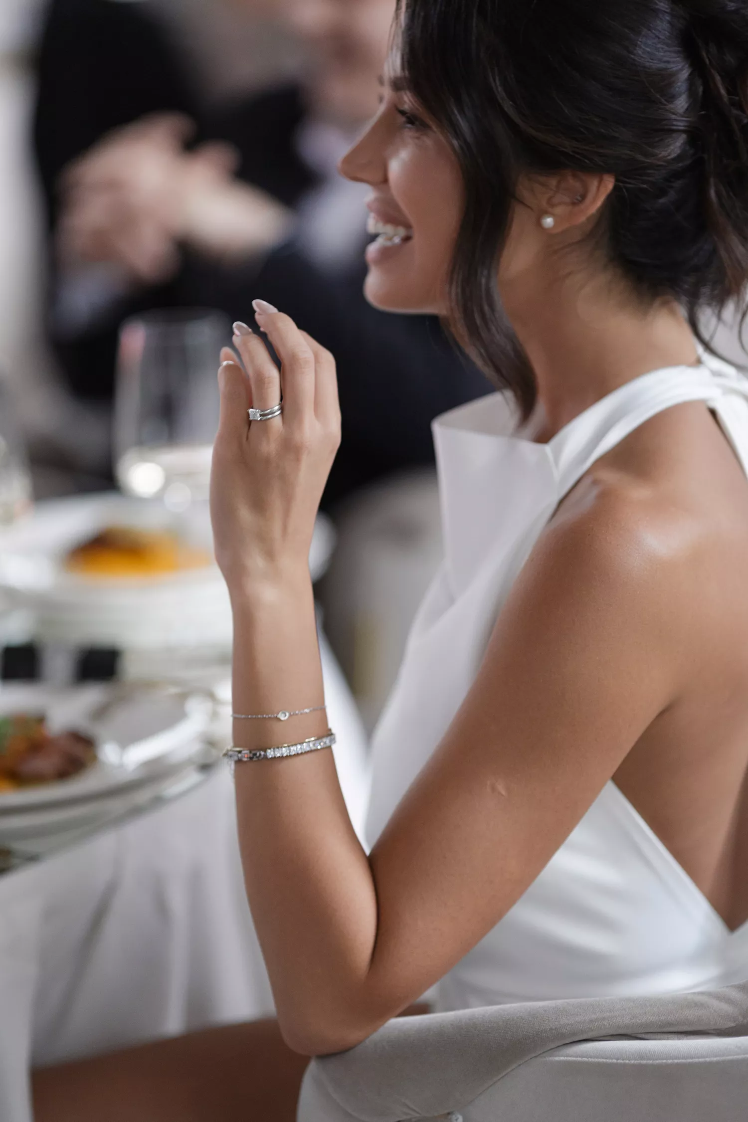 Bride Sitting at Wedding Table Holding Up Left Hand to Show Off Engagement Ring