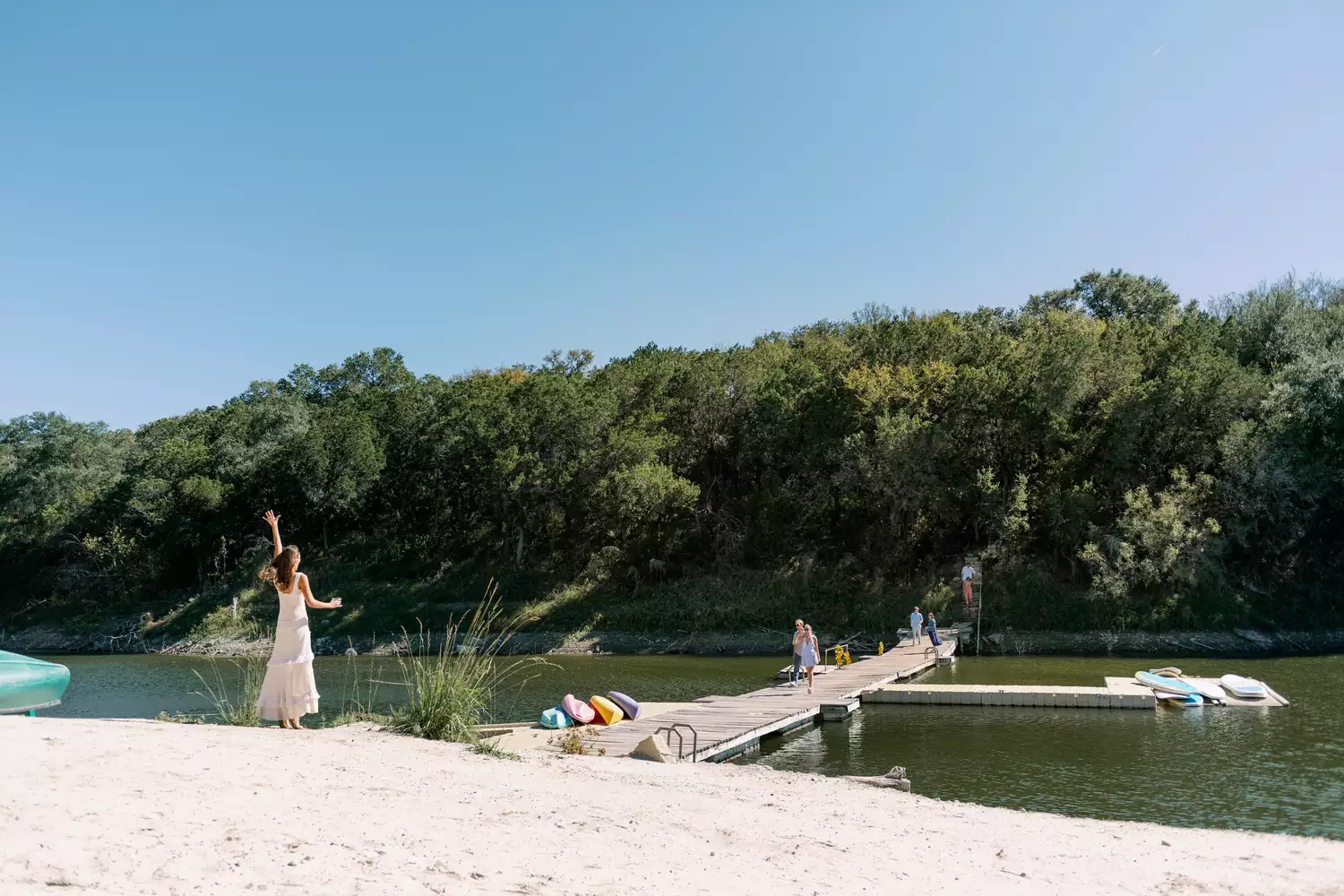 A bride greeting guests at her summer camp themed wedding in Texas.