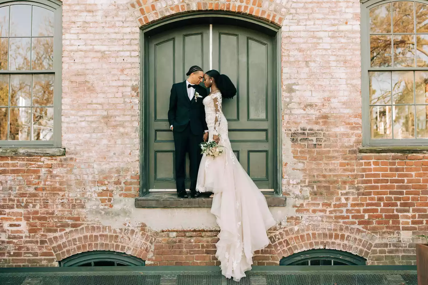 Bride and groom standing outside historic building during their wedding.