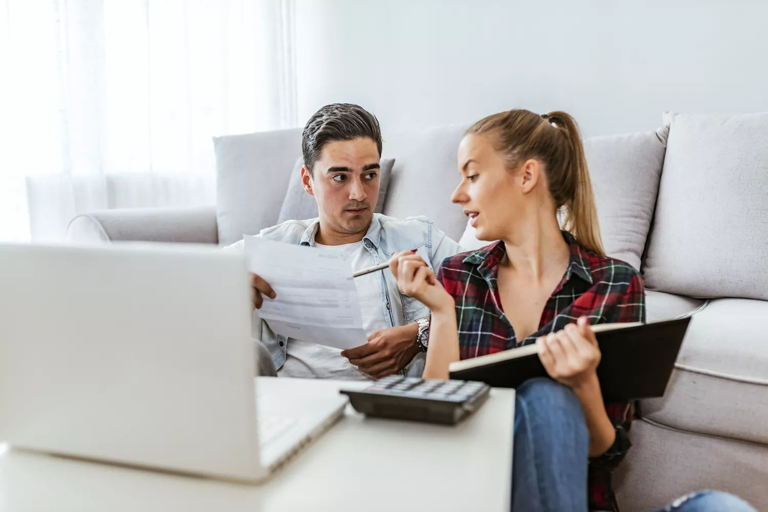Photo of Depressed young couple doing their accounting in their living room during the day