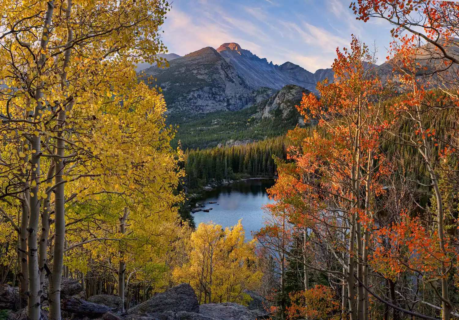 Fall foliage overlooking a lake and mountains at Rocky Mountain National Park in Colorado.