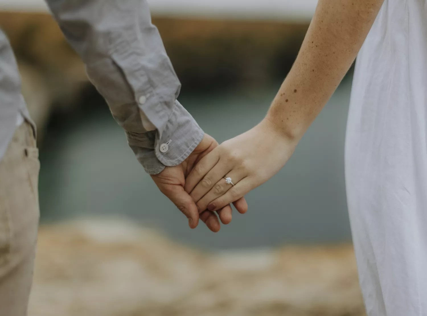 man and woman holding hands to show off woman's engagement ring