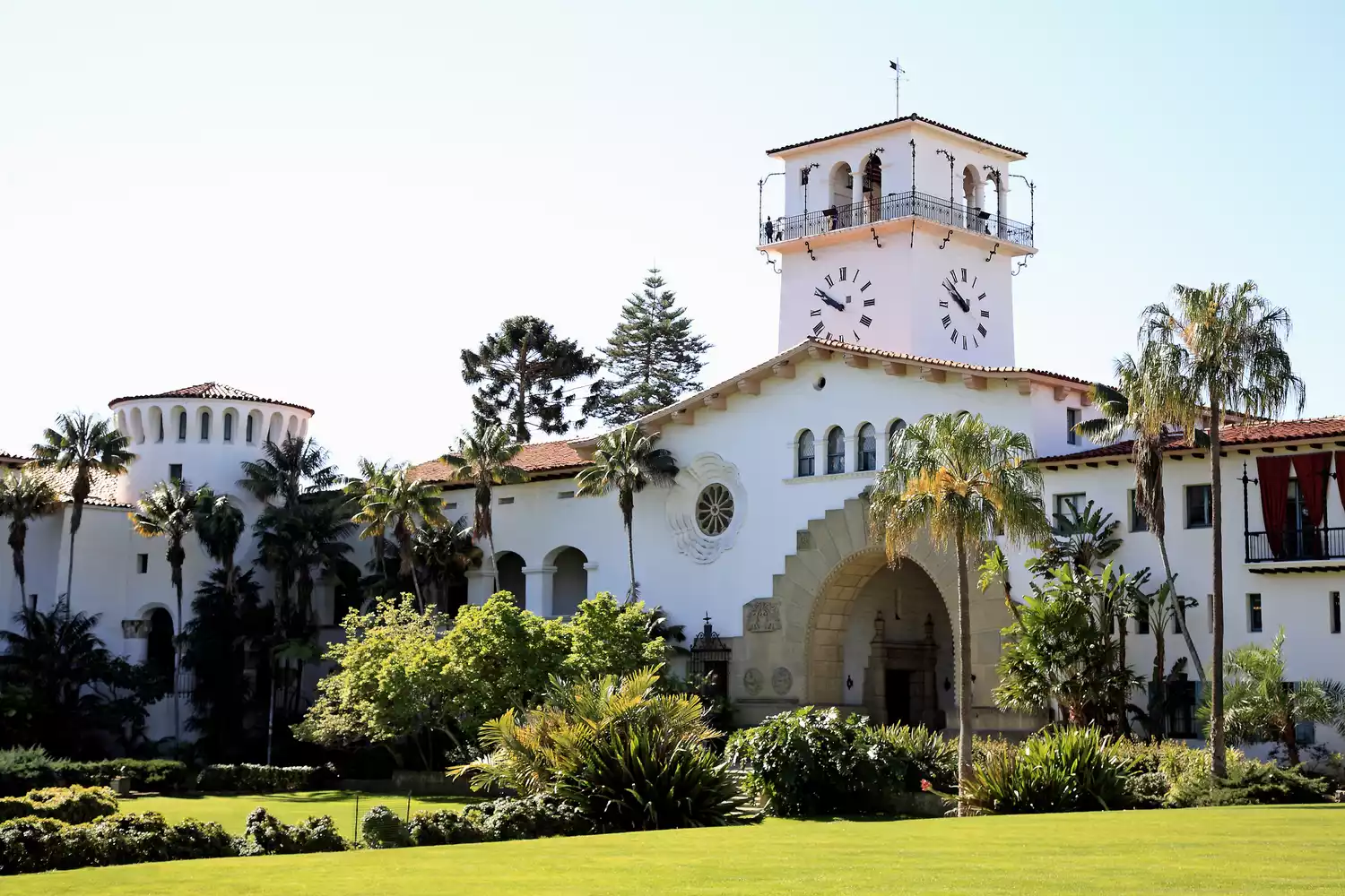 Exterior view of green lawn and trees outside Santa Barbara Courthouse.