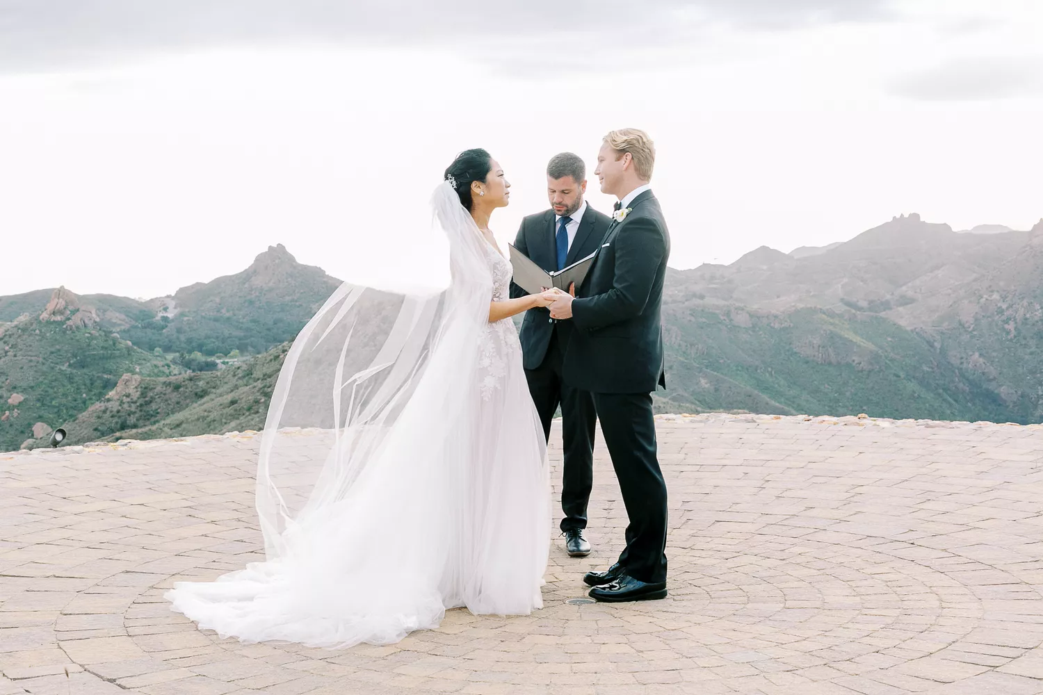 bride and groom holding hands during elopement ceremony overlooking the mountains