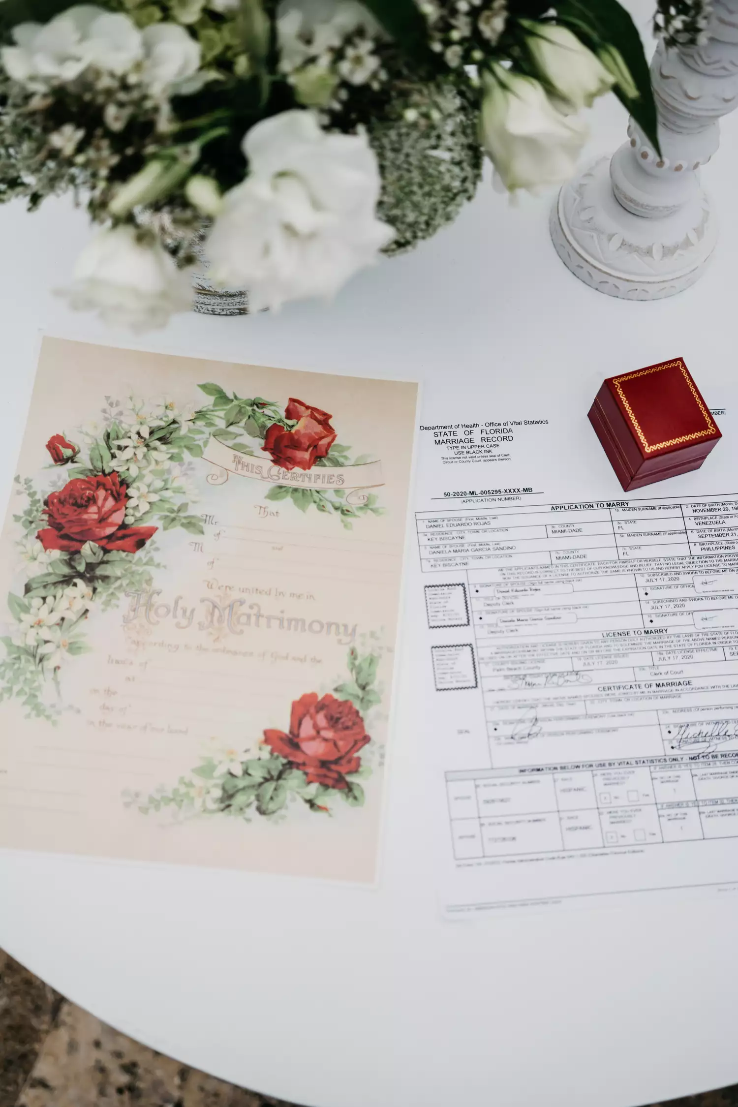 photo of marriage license with ring box and flowers