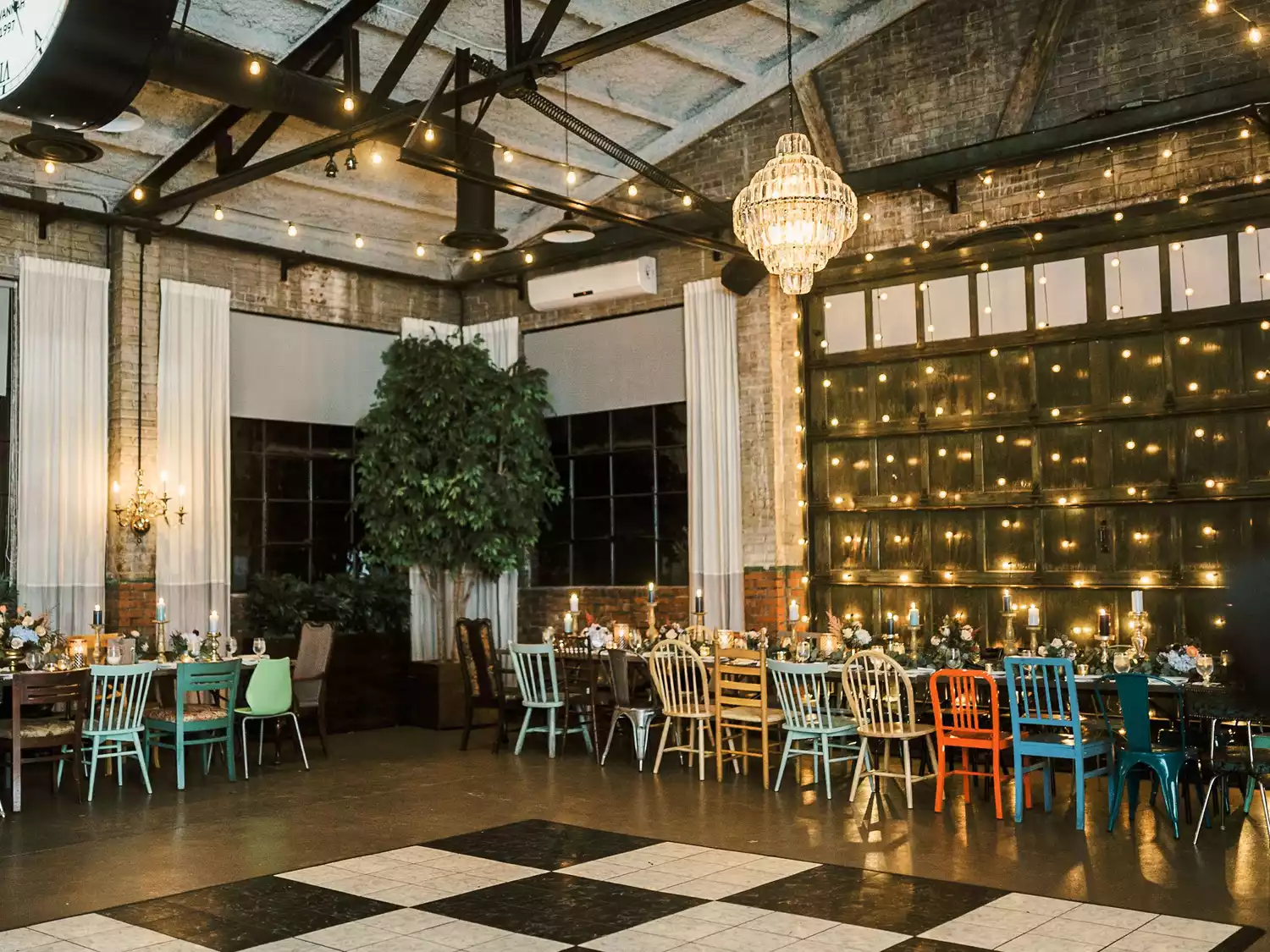 Soho South Cafe wedding reception set with colorful mismatched chairs and a black and white dance floor.