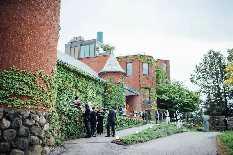 Exterior view of guests waiting outside ivy-covered brick walls at Decordova sculpture museum