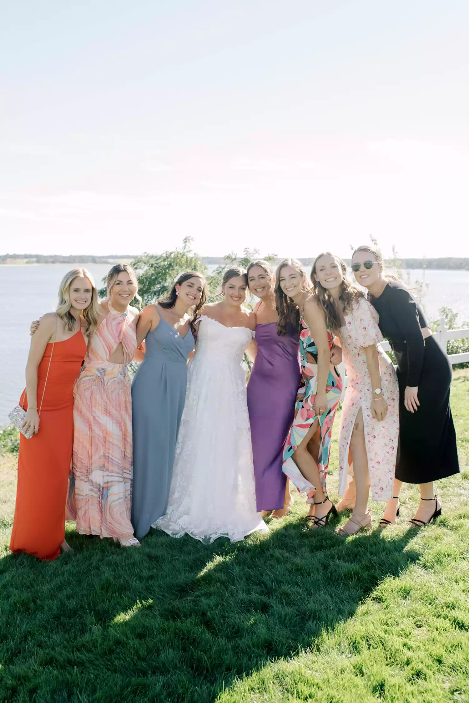 Bride Posing With Guests in Colorful Dresses