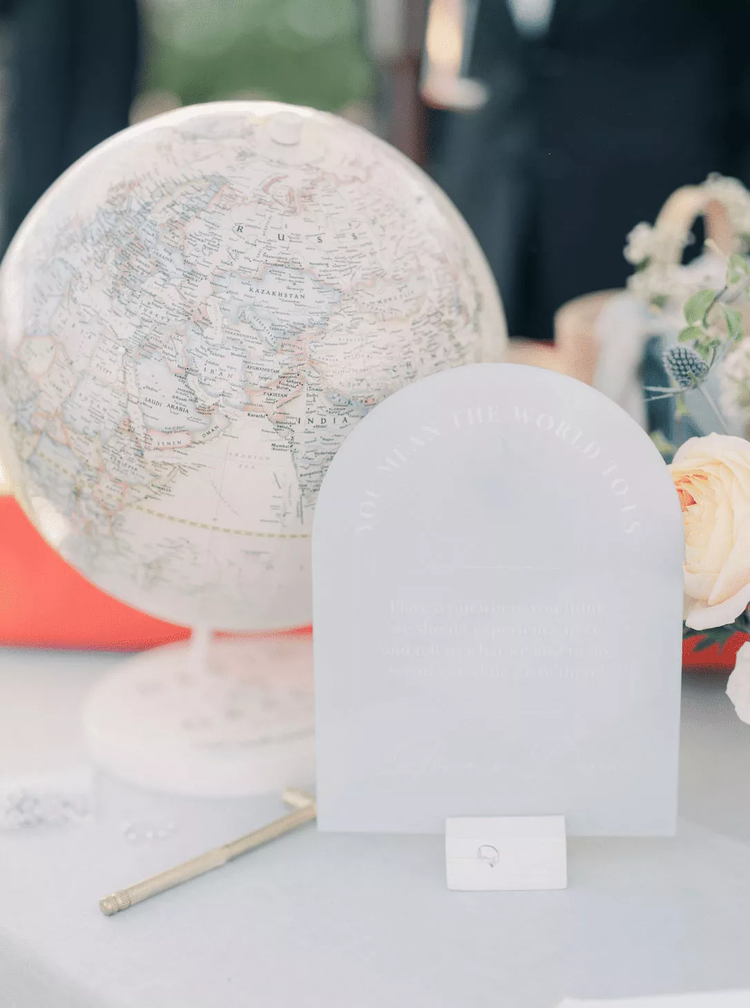 Guest Book Table With an Arched Sign in Front of a Globe