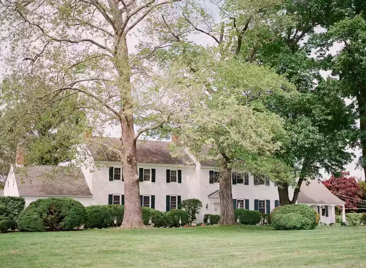 A white farmhouse backyard wedding venue in Maryland on a sunny summer day.