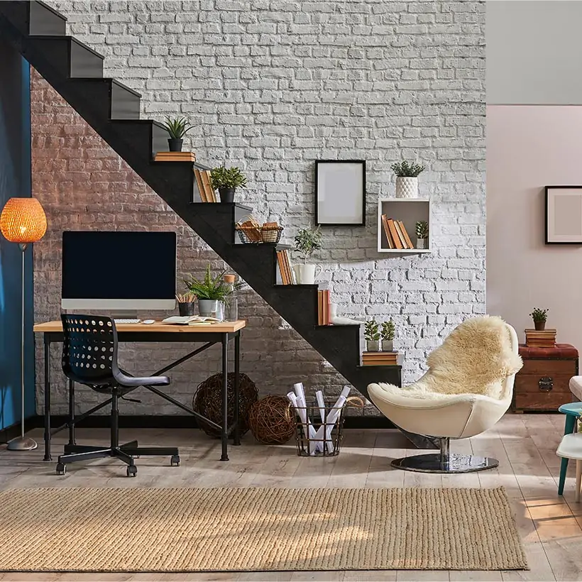 Convert your storage space under the staircase into a compact home office with built-in shelves and a desk