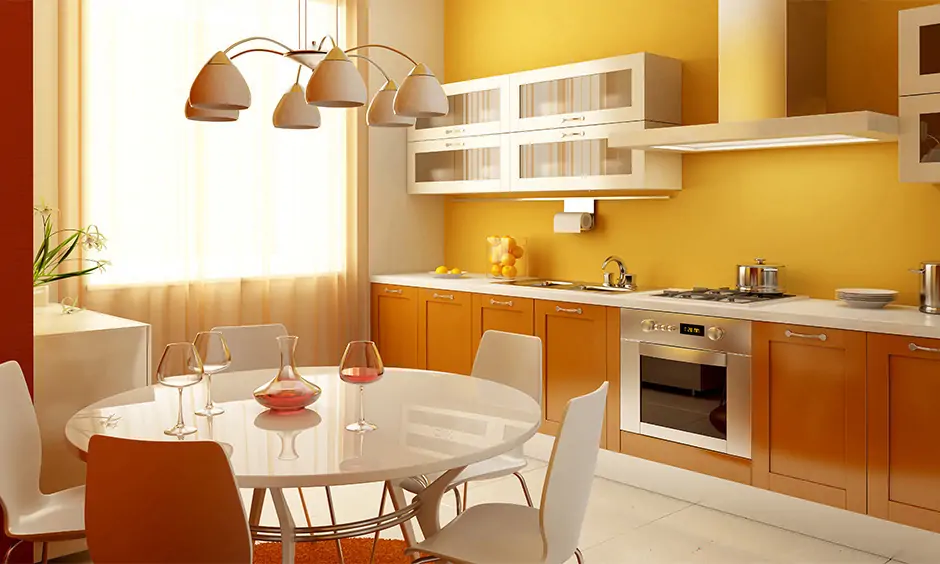 Yellow and orange shade monochromatic colour scheme interior design in an open kitchen cum dining area