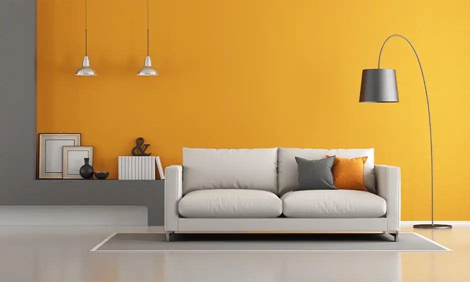 Sleek black metal minimal tall lamp for living room blends in beautifully with the orange wall and white sofa.