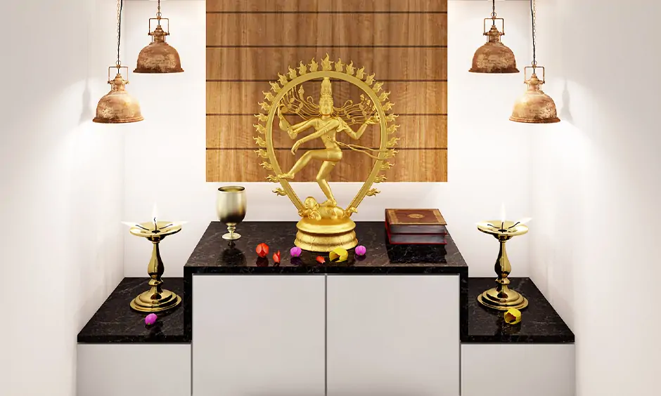 Dropdown lights on both the side of the idol are the pooja room decoration lights with cabinets and back wooden panel.