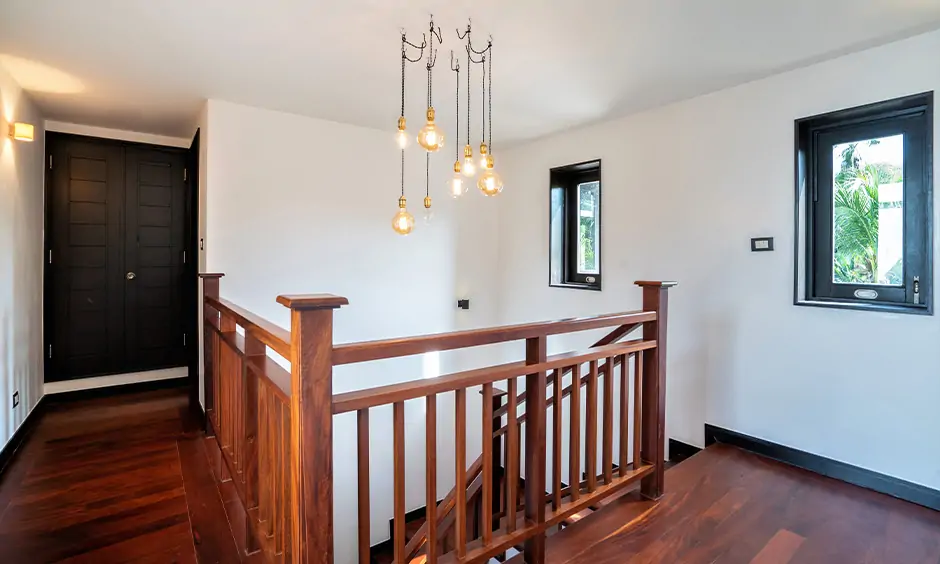 Classic indoor wood stair railing design with industrial hanging lights