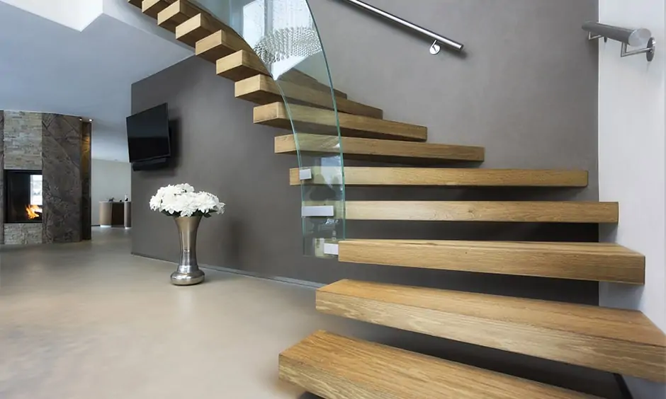 Wooden staircase design with curved glass panel running along one side looks elegant