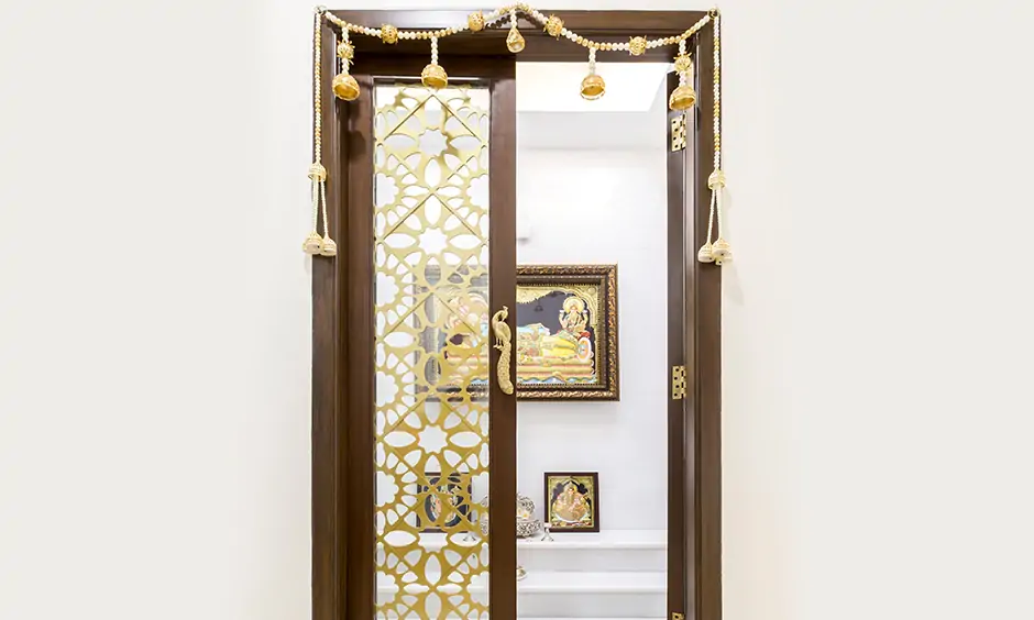 Decorative pooja room glass door design that has some metal detailing to create an eye-catching look