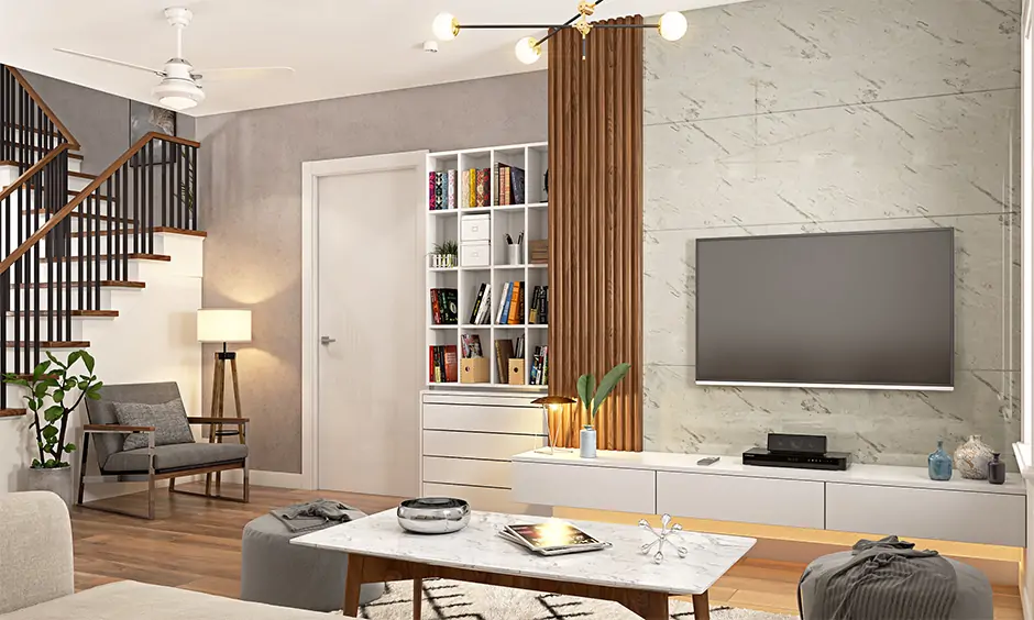 The library reading room is designed next to the living room stairs with a bookshelf with handleless drawer cabinets